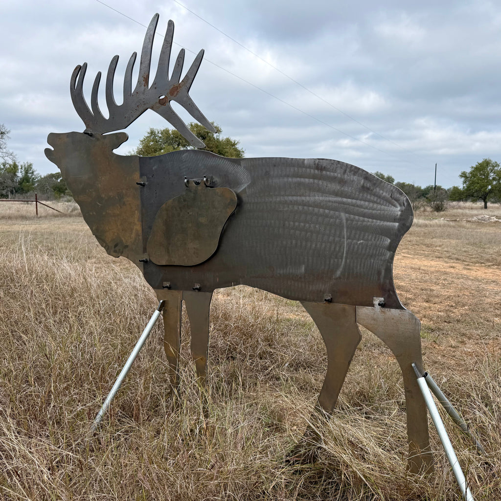 AR500 Steel Elk Bull target on a stand in a grassy outdoor area with trees in the background