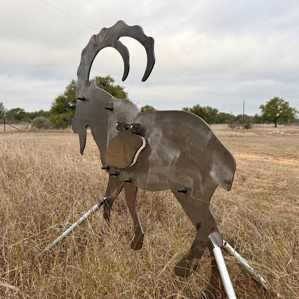 AR500 Steel Ibex Ram target on a stand in a grassy field with sky in the background