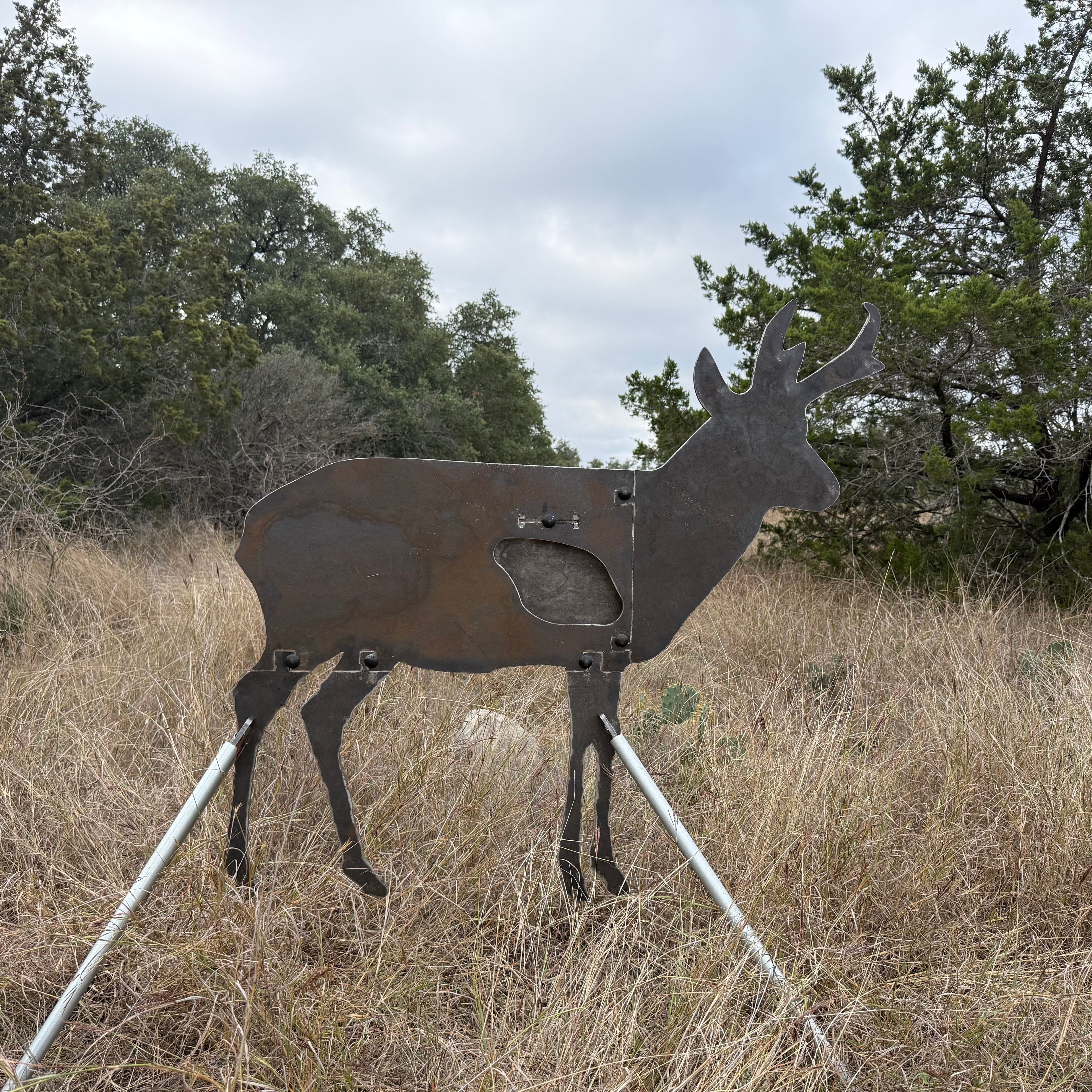 AR500 Steel Pronghorn Antelope target on a stand in a grassy outdoor area with trees in the background